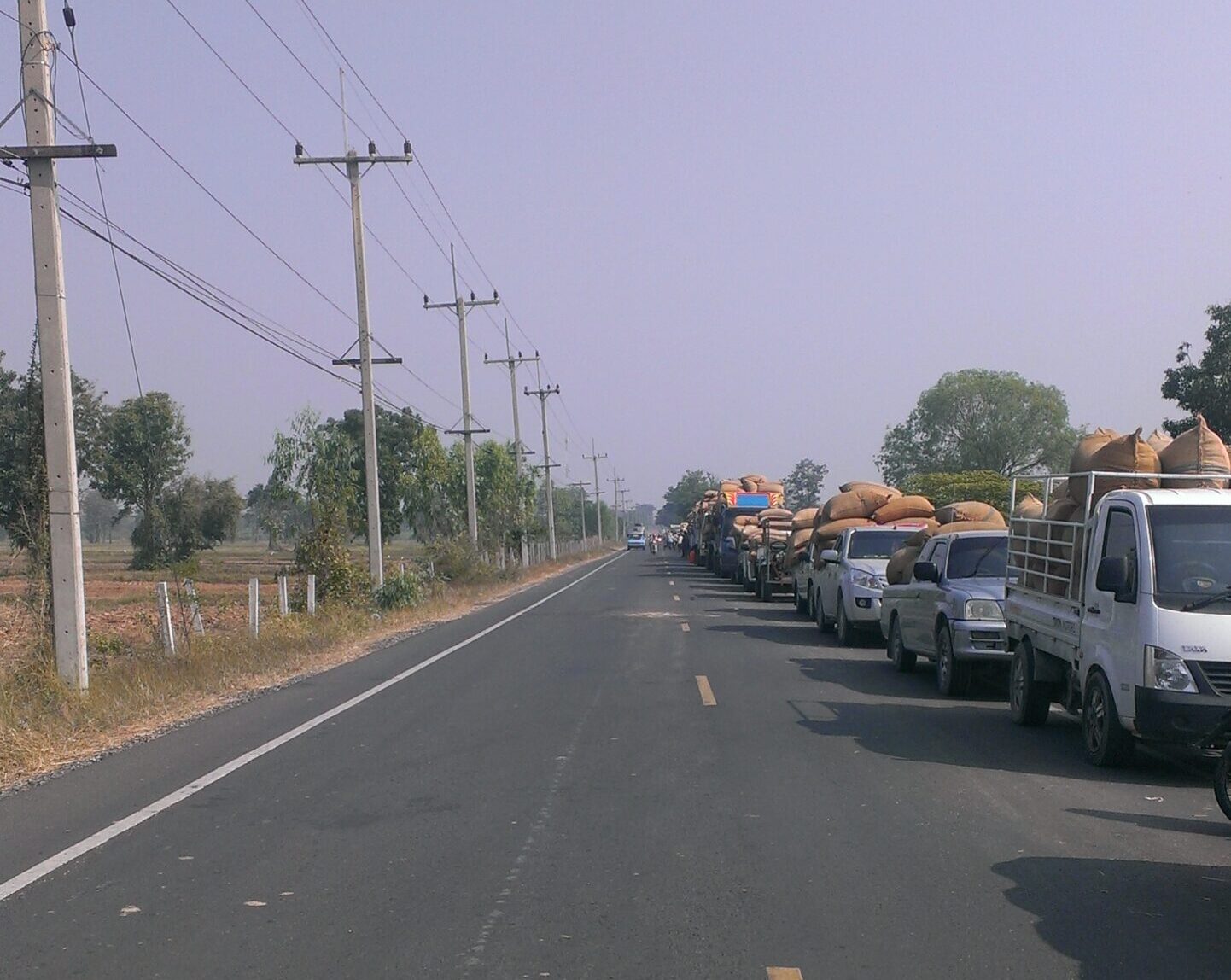 Rice harvest convoy on a rural road in Buriram province, northeast Thailand