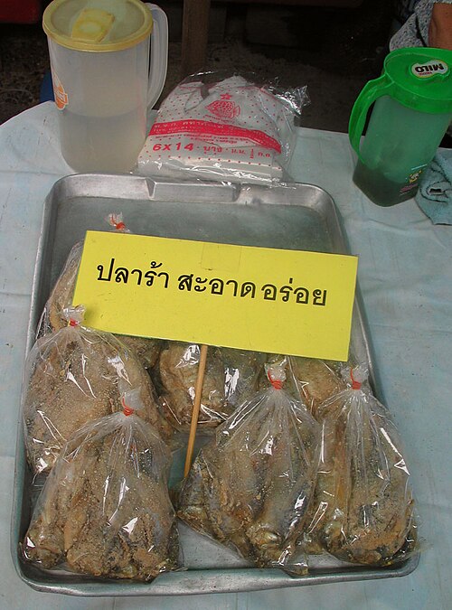 Pla ra on sale at a Thai market with a sign reading clean and delicious